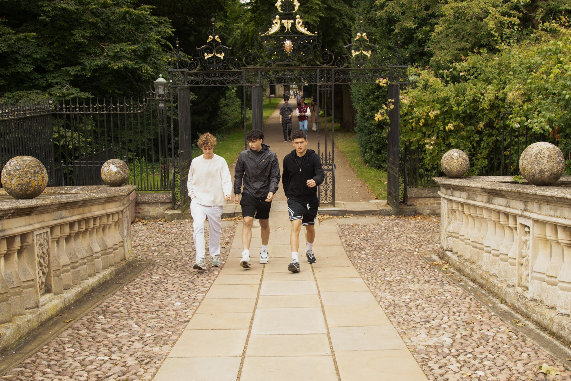 Students exploring a tree-lined path in Cambridge
